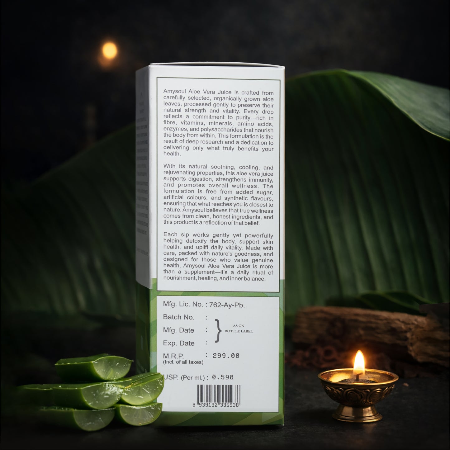 Aloe vera juice box with text on a dark background with a lit candle and green leaves.